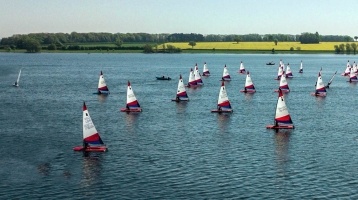 image of an expanse of water with many small white sailing boats on it. 